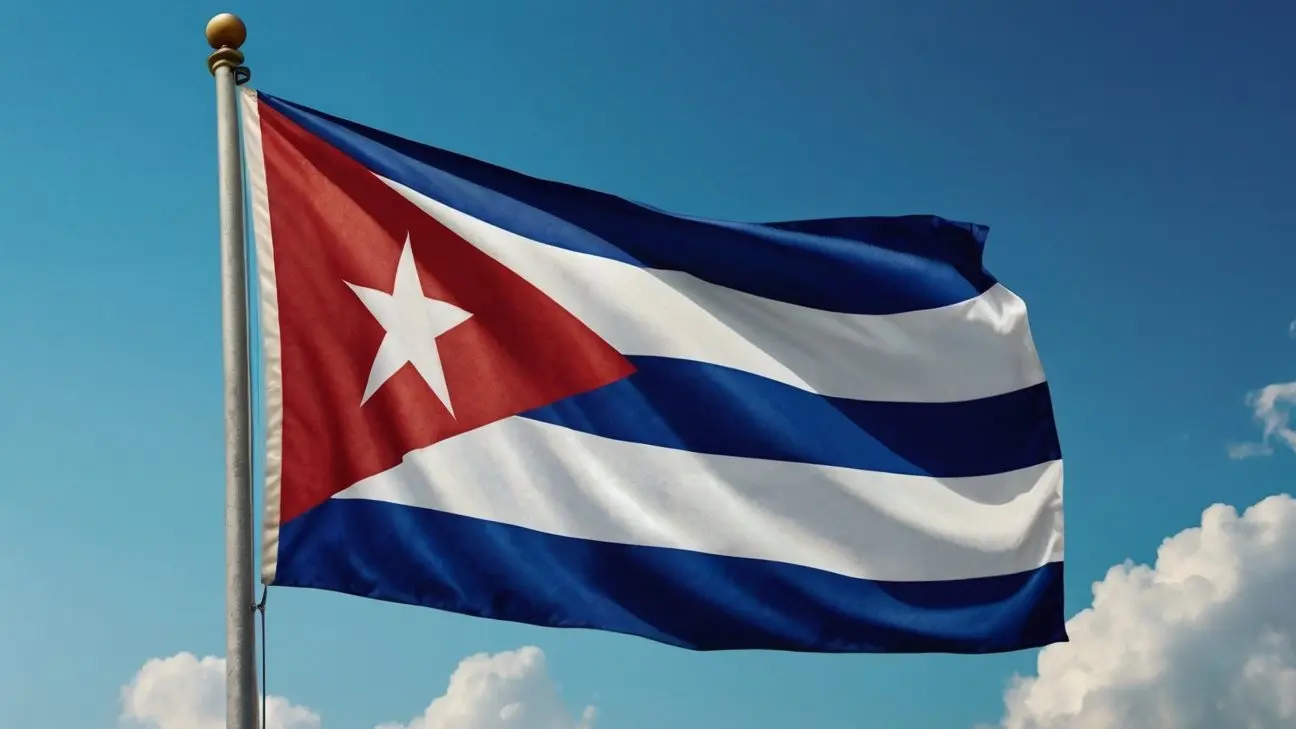 Bandera de Cuba ondeando en un asta bajo un cielo azul claro, símbolo de la identidad y el orgullo cubano.