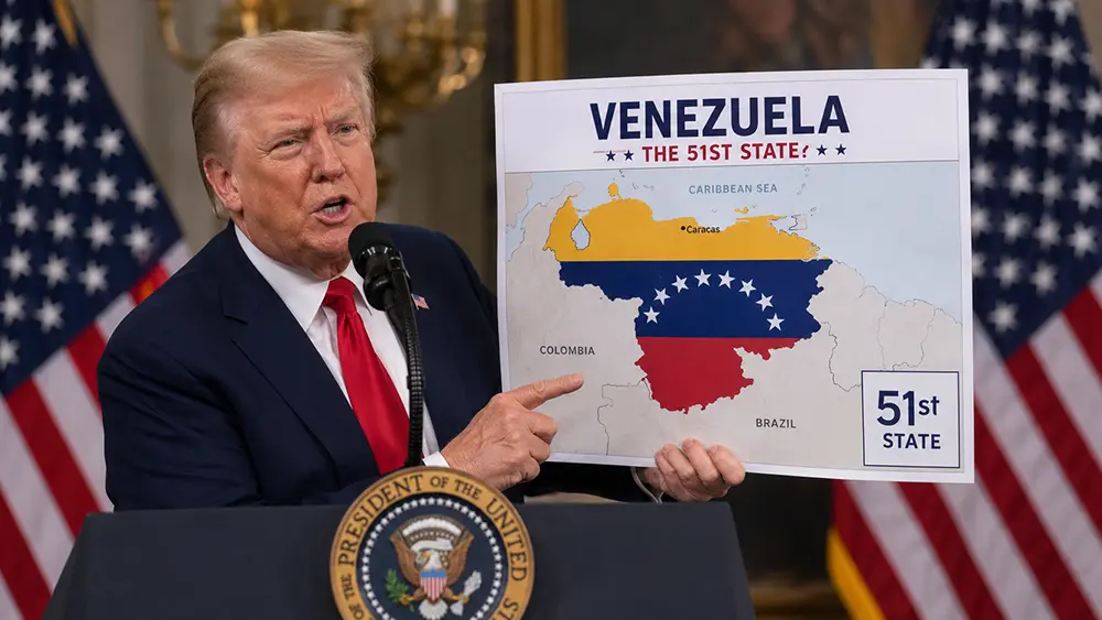Donald Trump hablando en un podio con banderas de Estados Unidos y Venezuela al fondo, en una imagen relacionada con sus declaraciones sobre convertir a Venezuela en el estado 51 y el interés por el petróleo venezolano.