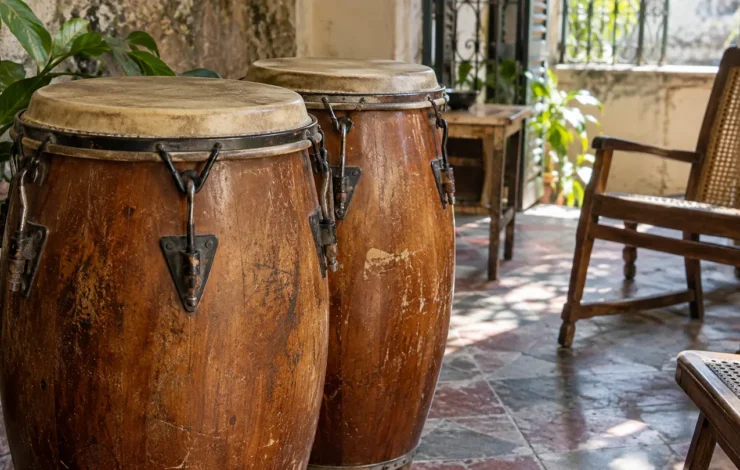 Dos tumbadoras de madera en un patio con sillas.